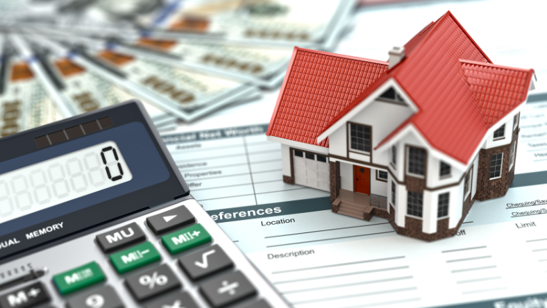 Calculator and model home displayed on table